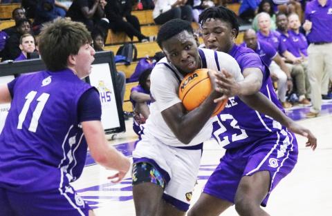 Columbia guard Isaac Broxey tries to drive past Gainesville’s Seth Childers (11) and Jordan Bodie (23) on Thursday night. (JORDAN KROEGER/Lake City Reporter)