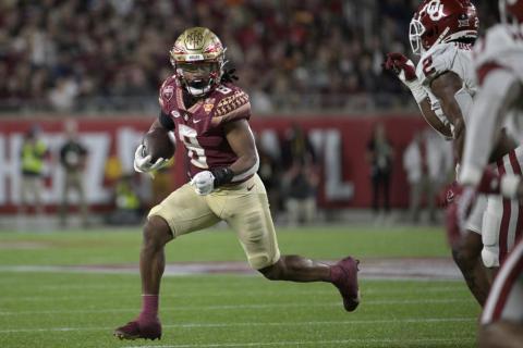 Florida State running back Treshaun Ward rushes as Oklahoma linebacker David Ugwoegbu defends during the Cheez-It Bowl on Thursday in Orlando. (PHELAN M. EBENHACK/Associated Press)