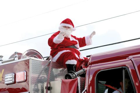Santa Claus waves atop a firetruck during last year’s Fort White Christmas parade. (FILE)