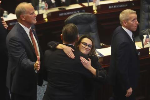 Rep. Bob Rommel (R-Naples) is hugged by Rep. Josie Tomkow (R-Polk City) after his SB 2-A Property Insurance bill he co-sponsored passed Wednesday in the House of Representatives in Tallahassee. At left is Rep. Bobby Payne (R-Palatka); at right is House Speaker Paul Renner (R-Palm Coast). (PHIL SEARS/Associated Press)