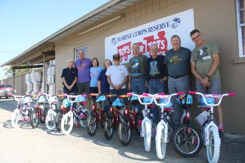 Inga Dwyer (from left), Toys for Tots Coordinator stands with Suwannee Bicycle Association members Mick Shea, Sharon Shea, Nancy Kelley, Mike Kelley, Michael Toffolo, Dale Nanny, George Litteral and Mark Wiencek after they donated 12 bikes to the local Toys for Tots program. (TONY BRITT/Lake City Reporter)