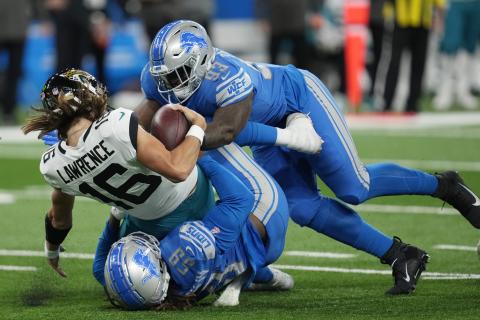 Jacksonville Jaguars quarterback Trevor Lawrence (16) is sacked by Detroit Lions linebacker James Houston (59) and defensive end Josh Paschal (93) during Sunday's game in Detroit. (PAUL SANCYA/Associated Press)