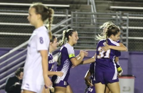Columbia’s Mia Brasel is embraced by teammates Sydney Rivas (31) and Skyler Ziegaus (left) after her goal as Gainesville’s Emily Brown (8) walks away Wednesday night. (MORGAN MCMULLEN/Lake City Reporter)