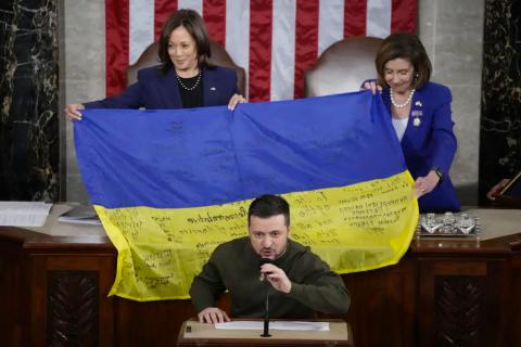 Vice President Kamala Harris and House Speaker Nancy Pelosi of Calif., right, react as Ukrainian President Volodymyr Zelenskyy presents lawmakers with a Ukrainian flag autographed by front-line troops in Bakhmut, in Ukraine's contested Donetsk province, as he addresses a joint meeting of Congress on Capitol Hill in Washington, Wednesday. (JACQUELYN MARTIN/Associated Press)