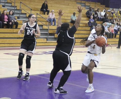 Columbia’s Eriel Baker goes for a layup attempt as Fort White’s N’Coreyia Atkins gets in her way. (MORGAN MCMULLEN/Lake City Reporter)