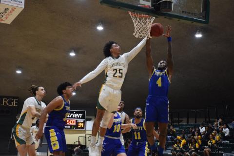 FGC forward Antewan Webber defends a shot from Trinity Baptist forward Marc Maisonnet on Monday night. (COURTESY OF FGC)