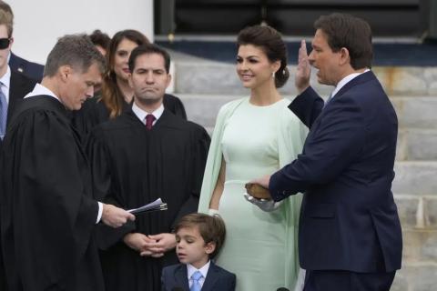 Florida Gov. Ron DeSantis, right, is sworn by Florida Supreme Court Chief Justice Carlos Muniz, left, to begin his second term during an inauguration ceremony outside the Old Capitol on Tuesday in Tallahassee. Looking on is DeSantis’ wife Casey, second from right, and their son Mason. (LYNNE SLADKY/Associated Press)