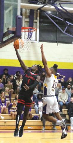 Fort White guard Najeeb Smith make a layup against Union County guard Thomas Williams on Friday. (MORGAN MCMULLEN/Lake City Reporter)