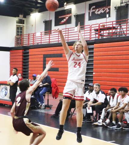 Fort White forward Brandon DeMartino shoots over Oak Hall’s Ryan McKinny on Thursday night. (MORGAN MCMULLEN/Lake City Reporter)