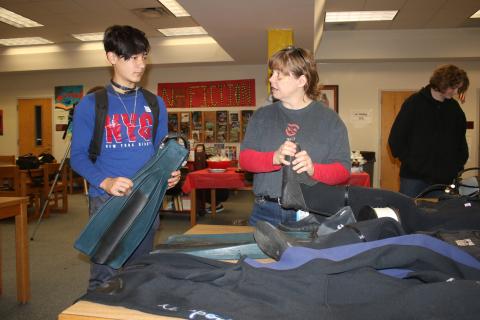 Logan Wilson (left), a Fort White High School sophomore listens to Jackie Clark, a FWHS English teacher, as she shows off some of her cave diving equipment on Friday. (TONY BRITT/Lake City Reporter)
