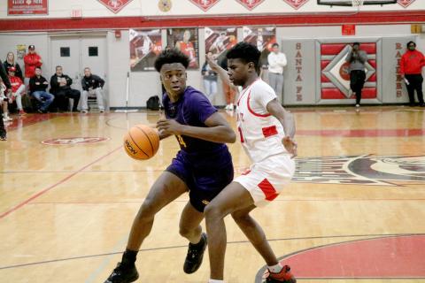 Columbia forward Ty’jahn Wright drives to the basket while defended by Santa Fe forward Antonio Hall on Friday night. (JORDAN KROEGER/Lake City Reporter)