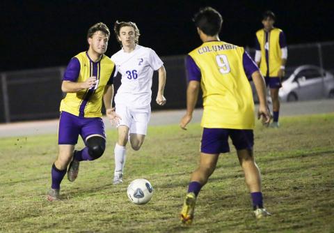 Columbia’s Mickey Johnson (11) passes to teammate Bryson Kyi (9) during Tuesday’s match against Palatka. (BRENT KUYKENDALL/Lake City Reporter)