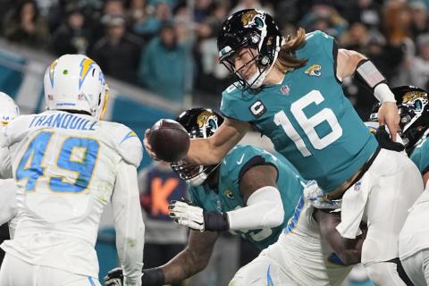 Jacksonville Jaguars quarterback Trevor Lawrence (16) leaps for a two-point conversion against the Los Angeles Chargers during Saturday's wild-card playoff game in Jacksonville. (CHRIS CARLSON/Associated Press)