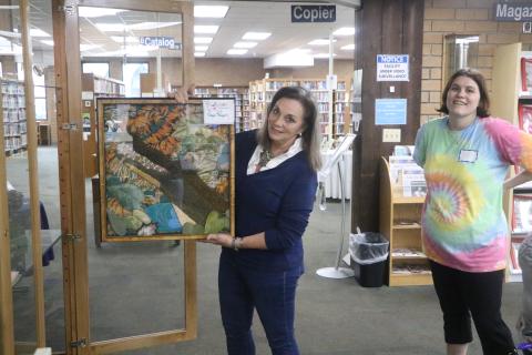 Gayle Rogers shows off a textile art work of an alligator that will be on display at the Columbia County Public Libary’s Main Branch as part of the Lady of the Lake Quilt Guild’s display through Feb. 21. (MORGAN MCMULLEN/Lake City Reporter)