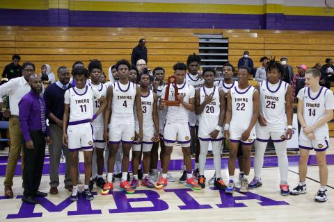 Columbia’s basketball team poses with the District 2-5A championship trophy after defeating Rickards 68-38 on Friday night. (BRENT KUYKENDALL/Lake City Reporter)
