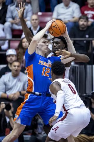 Florida forward Colin Castleton (12) works against Alabama center Charles Bediako, while Alabama guard Jaden Bradley (0) during Wednesday's game in Tuscaloosa, Ala. (VASHA HUNT/Associated Press)