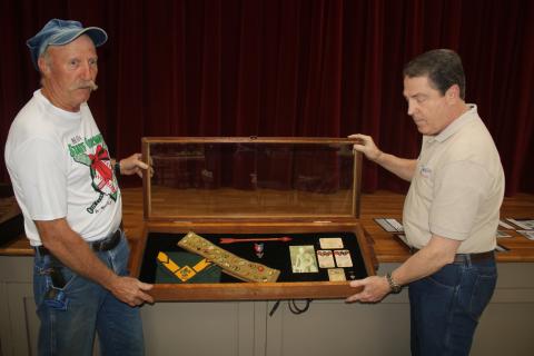 Jay Fraser (from left), local scouting organization representative and Darrel Mathis, Boy Scout Troop 85 Committee Chair, set up a display in the First Presbyterian Church Fellowship Hall that displays scouting memorabilia of Forrest Bradbury, the first Eagle Scout for the group from 1931. A reception will take place Sunday morning in the fellowship hall to celebrate 100 years of local scouting. (TONY BRITT/Lake City Reporter)