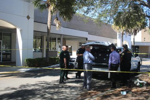 Law enforcement officers go through their latest updates on Tuesday morning at the mobile command post at the State of Florida Probation & Parole Services office. (TONY BRITT/Lake City Reporter)