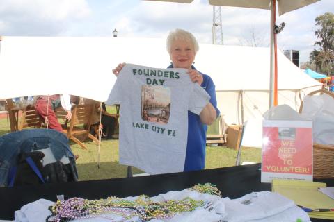 Ann Brown shows off a Founders Day T-shirt during the opening day Friday at the Olustee Festival. (TONY BRITT/Lake City Reporter)