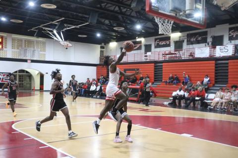 Fort White’s Najeeb Smith goes up for a layup in front of a Williston defender Friday night. (MORGAN MCMULLEN/Lake City Reporter)