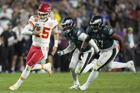 Kansas City Chiefs quarterback Patrick Mahomes runs against Philadelphia Eagles defensive tackle Javon Hargrave (97) and linebacker Haason Reddick (7) during Super Bowl 57 on Sunday in Glendale, Ariz. (ASHLEY LANDIS/Associated Press)