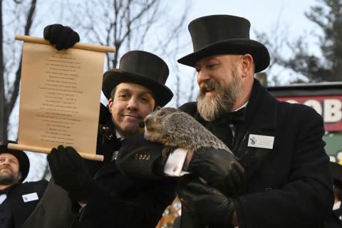 Groundhog Club handler A.J. Dereume holds Punxsutawney Phil, the weather prognosticating groundhog, while Vice President Dan McGinley reads the scroll during the 137th celebration of Groundhog Day on Gobbler’s Knob in Punxsutawney, Pa. (BARRY REEGER/Associated Press)