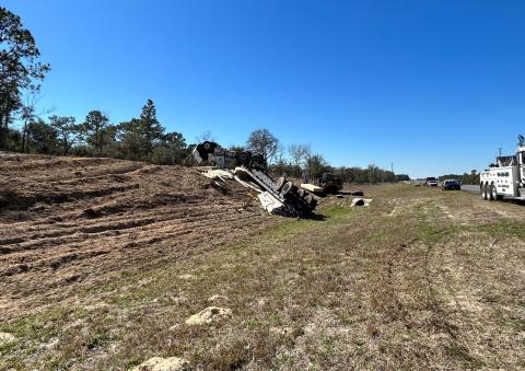 An overturned truck and trailer sit on the side of U.S. Highway 27 in Williston after it hit a median and crashed Thursday afternoon. (COURTESY)