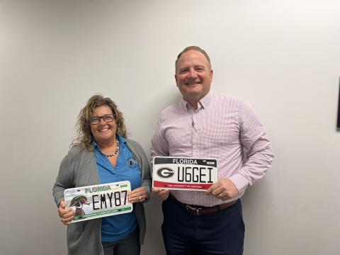 Columbia County Tax Collector Kyle Keen (right) holds the new University of Georgia license plate while Tracy Nettles, the director of motor services at the tax collector’s office, holds the Ducks Unlimited plate. (JAMIE WACHTER/Lake City Reporter)