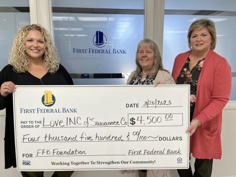 First Federal Bank Financial Manager Heather Thompson (left) and Regional Manager Pam Cochran (right) present Love INC Executive Director Martha Wood a $4,500 grant that will help the Suwannee County non-profit meet its monthly obligations in the community. (COURTESY)