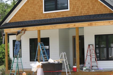 A worker with Stanley Crawford Construction works on the front of a house in the Hickory Cove neighborhood on Friday. The home will be part of the Parade of Homes this weekend. (JAMIE WACHTER/Lake City Reporter)