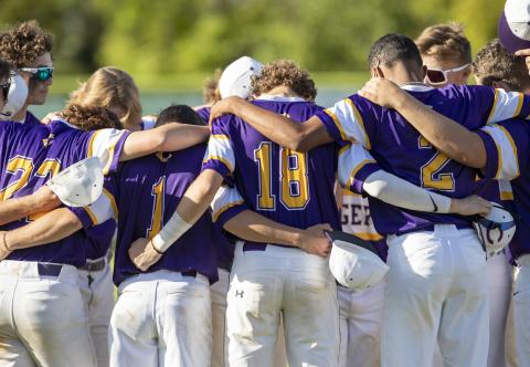Columbia teammates huddle before a game against on March 24. (ALAN YOUNGBLOOD/Special to the Reporter)