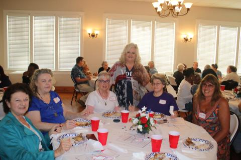 Columbia County Supervisor of Elections Tomi Brown (standing) makes the rounds at a dinner honoring election workers. (TONY BRITT/Lake City Reporter)