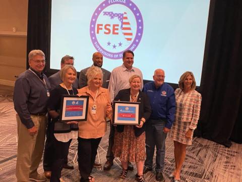 Columbia County Supervisor of Elections Tomi Brown (center) receives a U.S. Election Commission Clearinghouse Award for her office’s ‘Bubble it in’ T-shirt. (COURTESY)