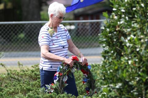Shirley Reaves with the Live Oak Garden Club places a wreath at the veterans memorial at the Live Oak Cemeteray during Monday’s Memorial Day ceremony. (JAMIE WACHTER/Lake City Reporter)