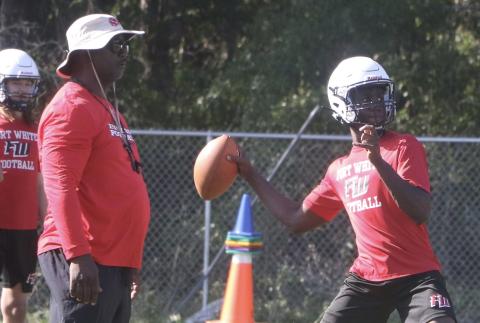 Fort White quarterback Jayden Jackson throws a pass next to head coach Demetric Jackson during Monday’s practice. (MORGAN MCMULLEN/Lake City Reporter)