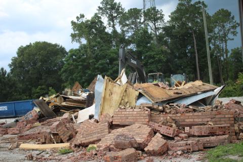 A construction crew takes down the last of the Ken’s Bar-B-Que and Steaks building on U.S. Highway 90 Wednesday afternoon to make way for a new Radiant Credit Union building. (TONY BRITT/Lake City Reporter)