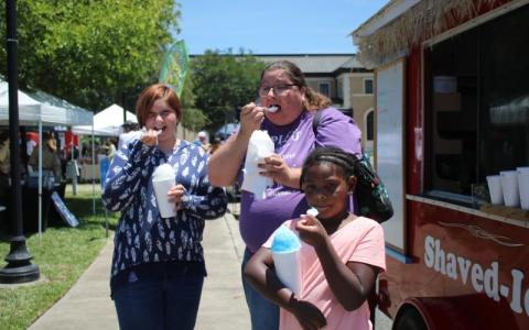 Hannah Hunter (from left), Jessica Frame and Kaleah Shead enjoy their cups of shaved ice while attending the Spring Market in Olustee Park in May 2021. (FILE)