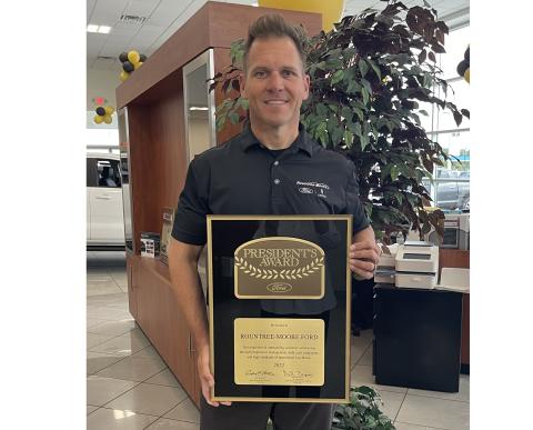 Rountree Moore Ford General Manager Stephen Jones holds up the Ford Motor Company’s President’s Award, which the company earned for outstanding customer satisfaction. (COURTESY)
