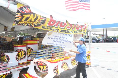 JD Morris, the Columbia High FFA alumni treasurer, adjusts a sign on the outside of the group’s fireworks tent at the Lake City Walmart on Tuesday. The fireworks tent is the FFA’s largest fundraiser. (MORGAN MCMULLEN/Lake City Reporter)