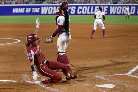 Oklahoma's Jayda Coleman slides into home plate to score past Florida State catcher Michaela Edenfield during the fifth inning of Game 1 of the Women's College World Series championship series on Wednesday in Oklahoma City. (NATE BILLINGS/Associated Press)