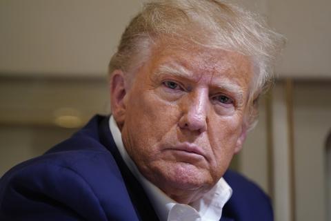 Former President Donald Trump listens as he speaks with reporters while in flight on his plane after a campaign rally at Waco Regional Airport on March 25 in Waco, Texas. (EVAN VUCCI/AP File)