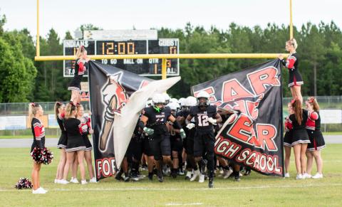 Fort White linebacker Lecosta Byrd (left) and receiver Najeeb Smith (right) lead the Indians on to the field for their spring game on May 23. (CHRISTINA FEAGIN/Special to the Reporter)