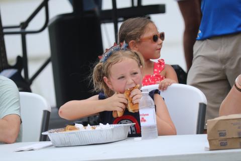 Rayva Boyle, 8, takes part in the hot dog eating contest Saturday at the Rotary Club of Lake City Downtown Independence Day celebration. Boyle stuffed down five hot dogs in the five-minute contest using a hot dog in each hand approach. (JAMIE WACHTER/Lake City Reporter)