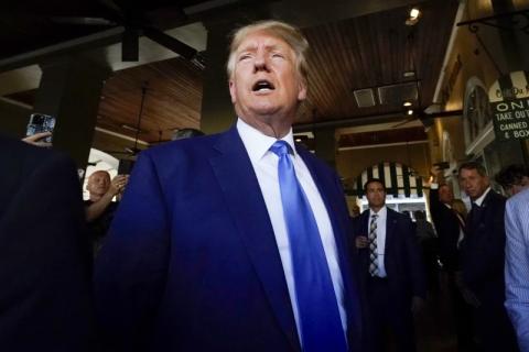 Former President Donald Trump visits Café du Monde in New Orleans on Tuesday. Trump received a new charge Thursday in the Mar-a-Lago investigation. (GERALD HERBERT/Associated Press)