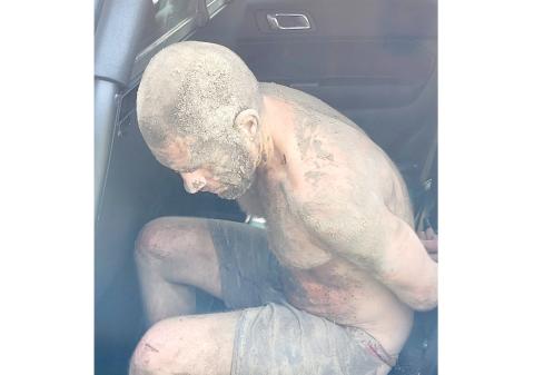 Scott Salanci is seated in a Columbia County Sheriff’s Office patrol car after hiding beneath a house Tuesday morning. (COURTESY COLUMBIA COUNTY SHERIFF’S OFFICE)