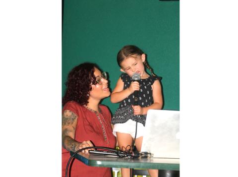 Amberlyn Gould (left) helps her three-year-old daughter, Addison, during a karaoke performance Wednesday night at Gators Dockside. (TONY BRITT/Lake City Reporter)