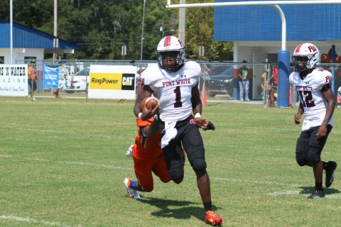 Fort White running back Dakota Fisher runs past a Taylor County tackler on Saturday. (JAMIE WACHTER/Lake City Reporter)