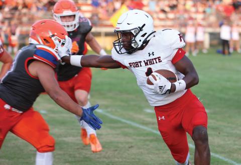 Fort White running back Dakota Fisher stiff arms a Branford defender during Friday night’s three-team jamboree at Trenton. (PAUL BUCHANAN/Special to the Reporter)