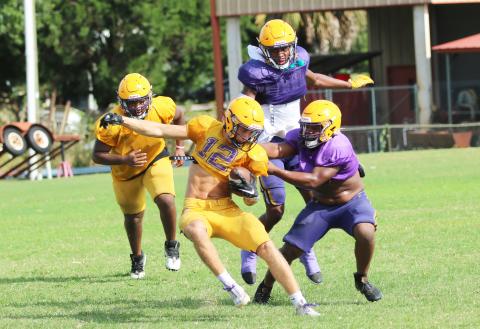 Columbia receiver Camdon Frier is tackled by linebacker Wilson Philemon (right) and safety Jerome Carter during Friday’s scrimmage. (JORDAN KROEGER/Lake City Reporter)
