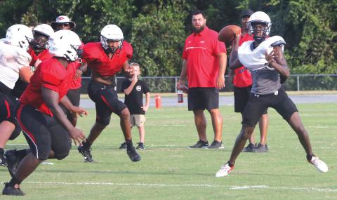 Fort White quarterback Jayden Jackson rolls out to throw a pass during Friday’s team scrimmage. (MORGAN MCMULLEN/Lake City Reporter)
